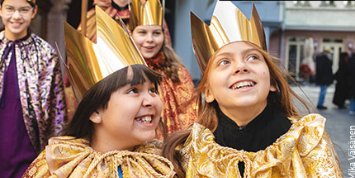 3 Kinder als Heilige drei Könige verkleidet mit goldenen Kronen auf dem Kopf