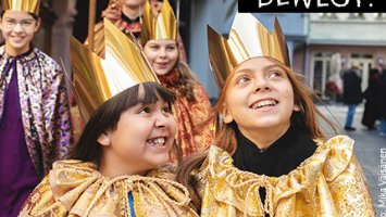 3 Kinder als Heilige drei Könige verkleidet mit goldenen Kronen auf dem Kopf