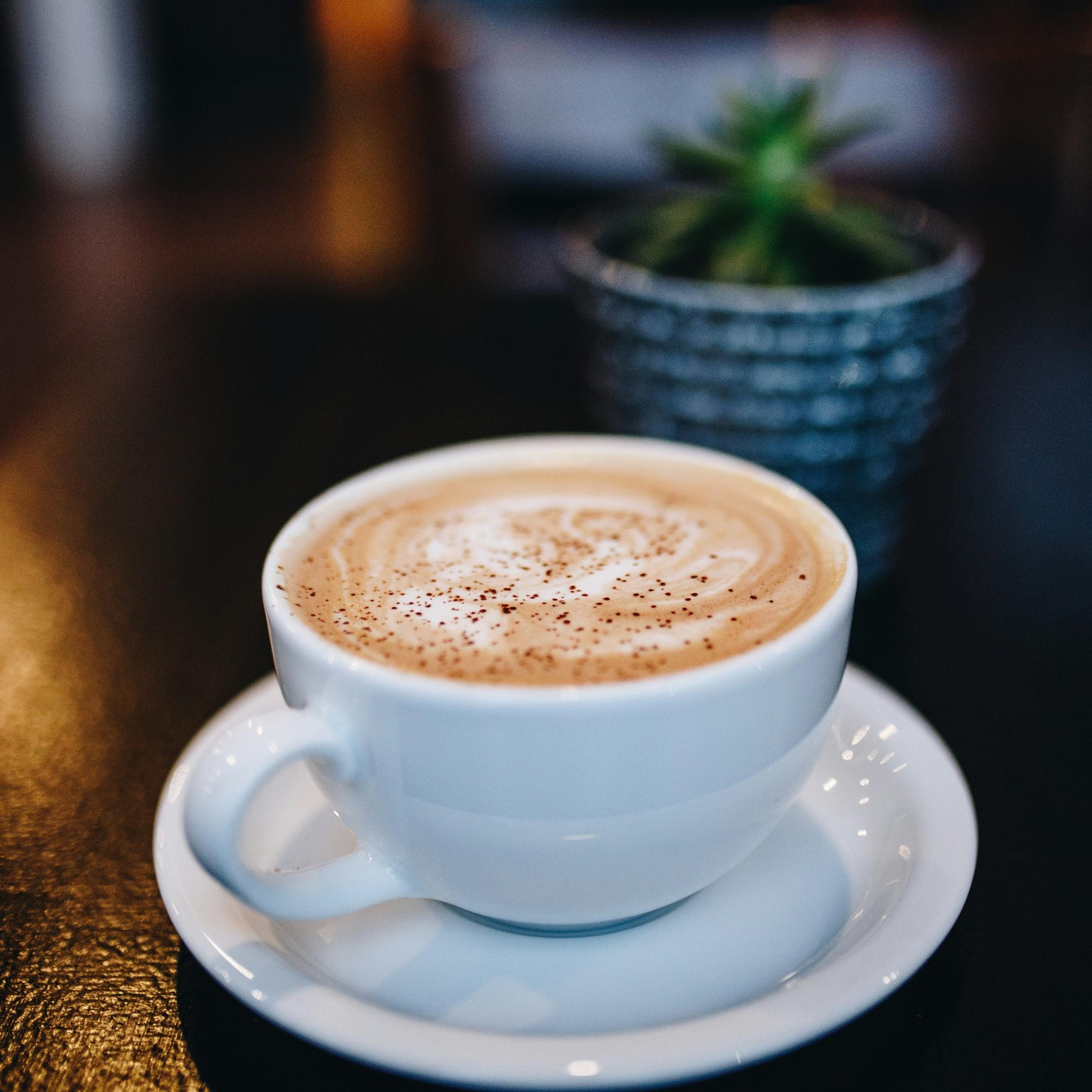 eine weiße Tasse mit cremigen Milchkaffee